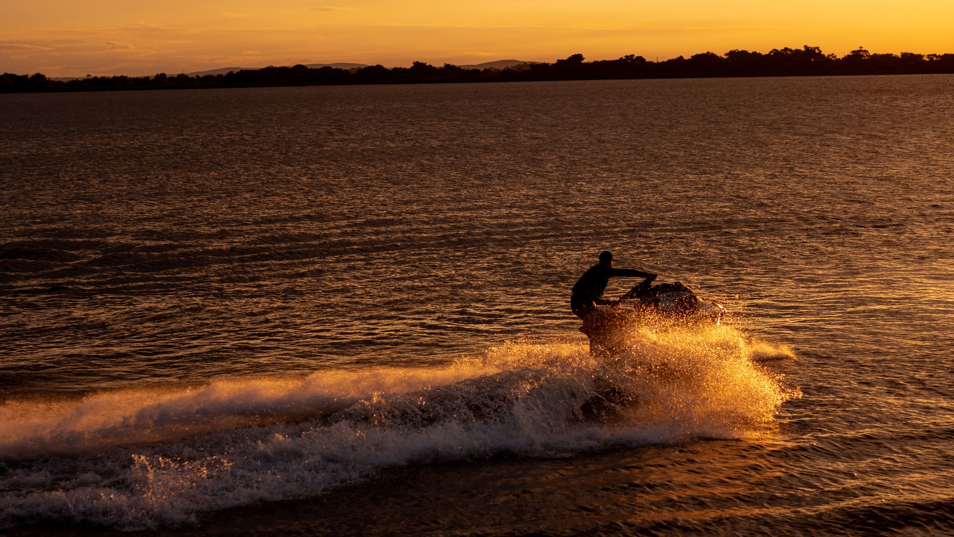 A man riding a jetski at sunset