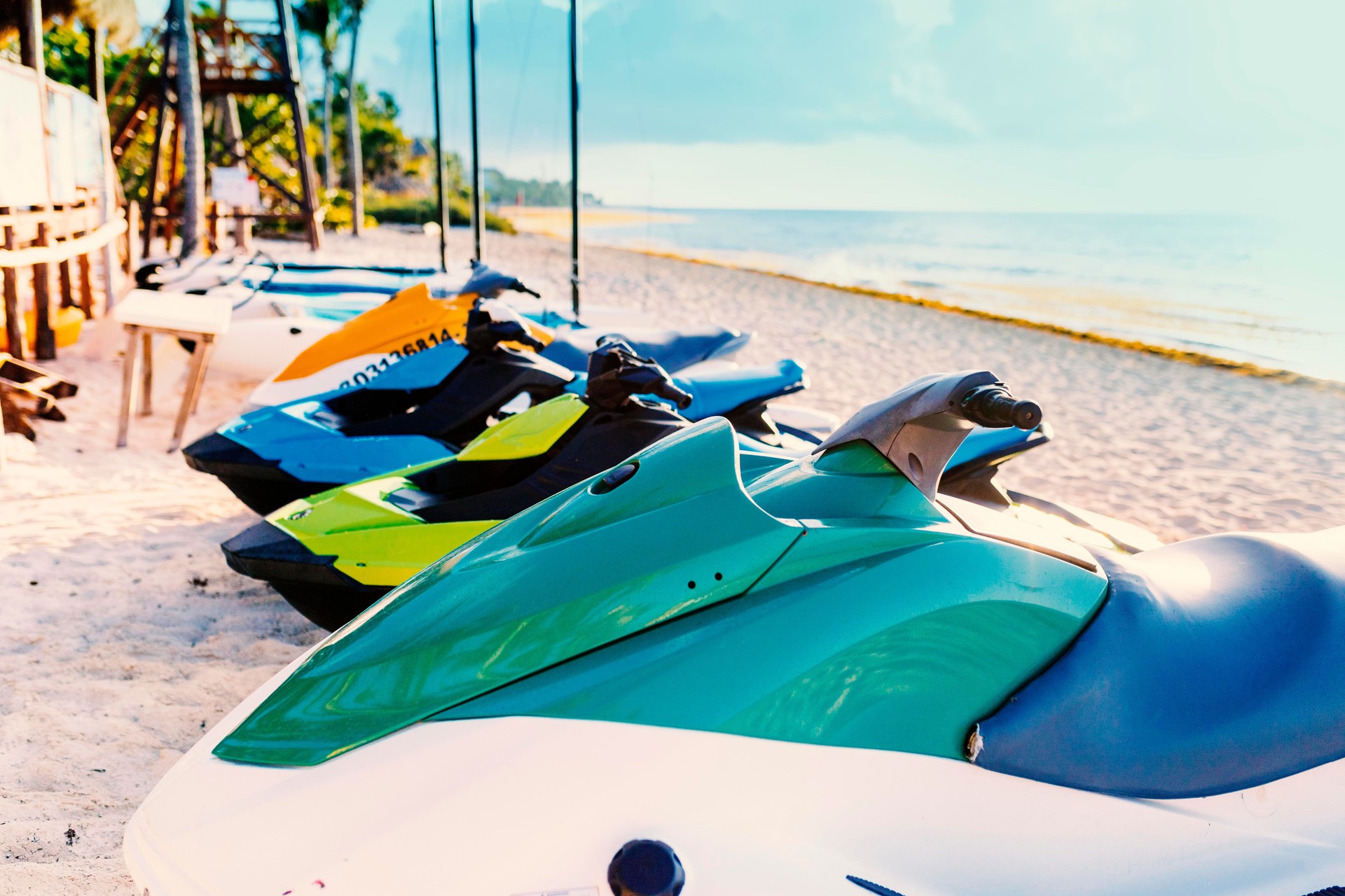 Row of Jet Skis to hire on a beautiful white Caribbean sandy beach on the Riviera Maya, Mexico beside the ocean on a sunny day
