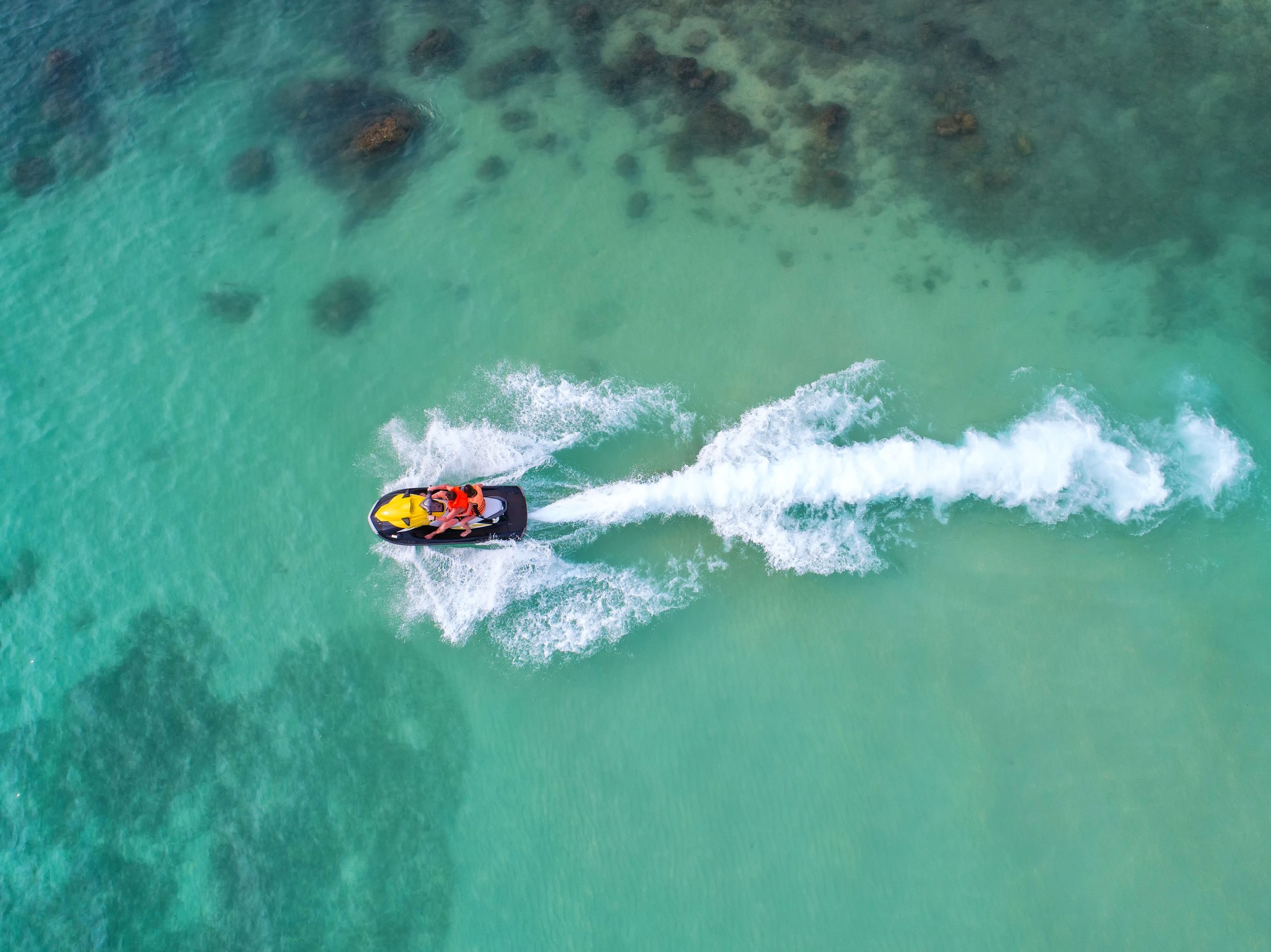 People are playing a jet ski in the sea.Aerial view. Top view.amazing nature background.The color of the water and beautifully bright. Fresh freedom. Adventure day.clear turquoise at tropical beach.