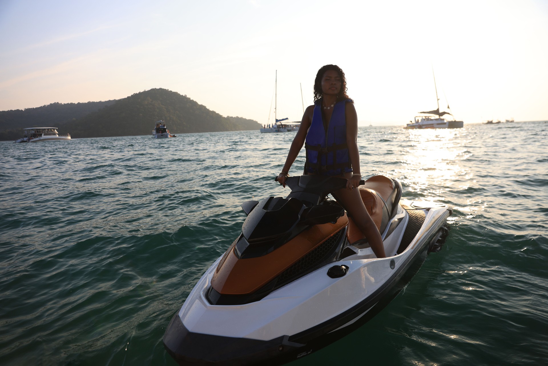 Black female having fun in summer, riding a jet ski. Summer vacation vibe, great time, blue sea and sky